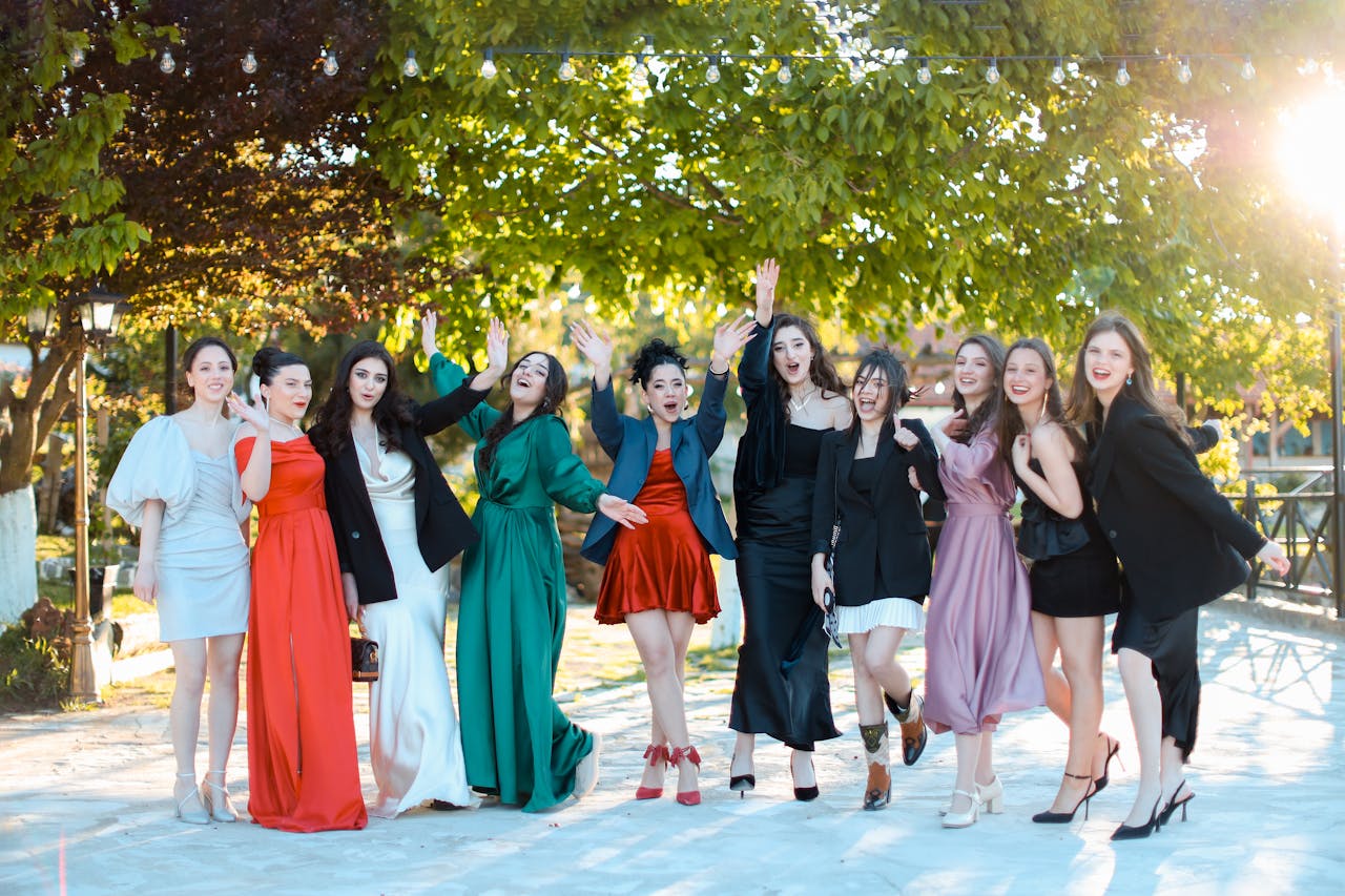 Services Group of well-dressed young women enjoying a celebration outdoors, exuding joy and friendship.